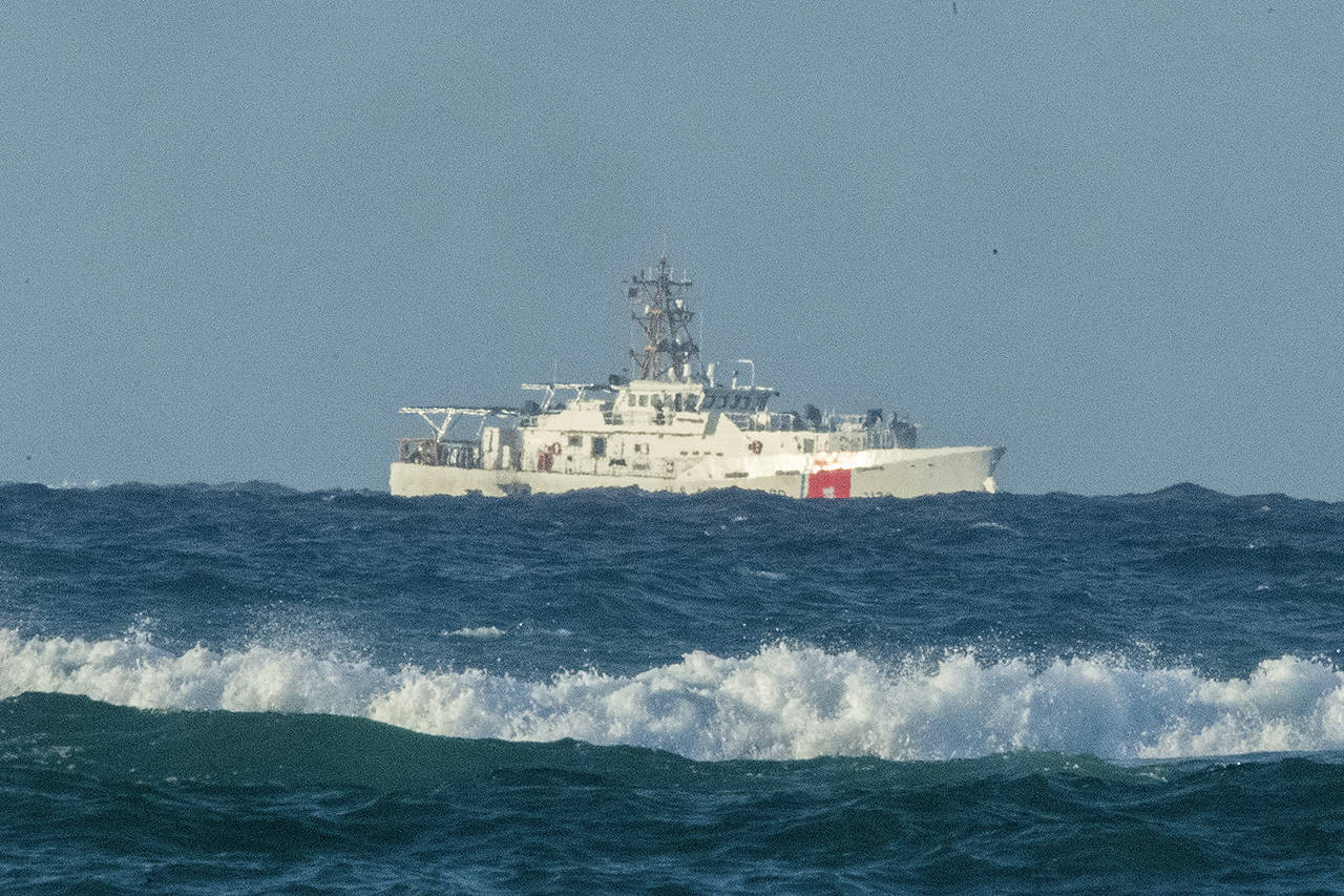 A U.S. Coast Guard cutter patrols the area of debris from a 737 cargo plane that crashed off Oahu on Friday near Honolulu. The plane made an emergency landing in the Pacific Ocean off the coast of Hawaii early Friday and both people on board were rescued. (Craig T. Kojima/Honolulu Star-Advertiser via AP)