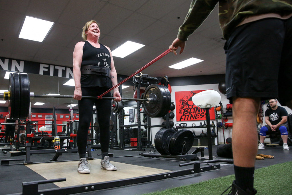 Cindy Buchan works out at Blinn Fitness in Everett on Wednesday. Buchan, 60, recently won a most-inspirational award in a weightlifting competition in Oregon, where she lifted 319 pounds. (Kevin Clark / The Herald)
