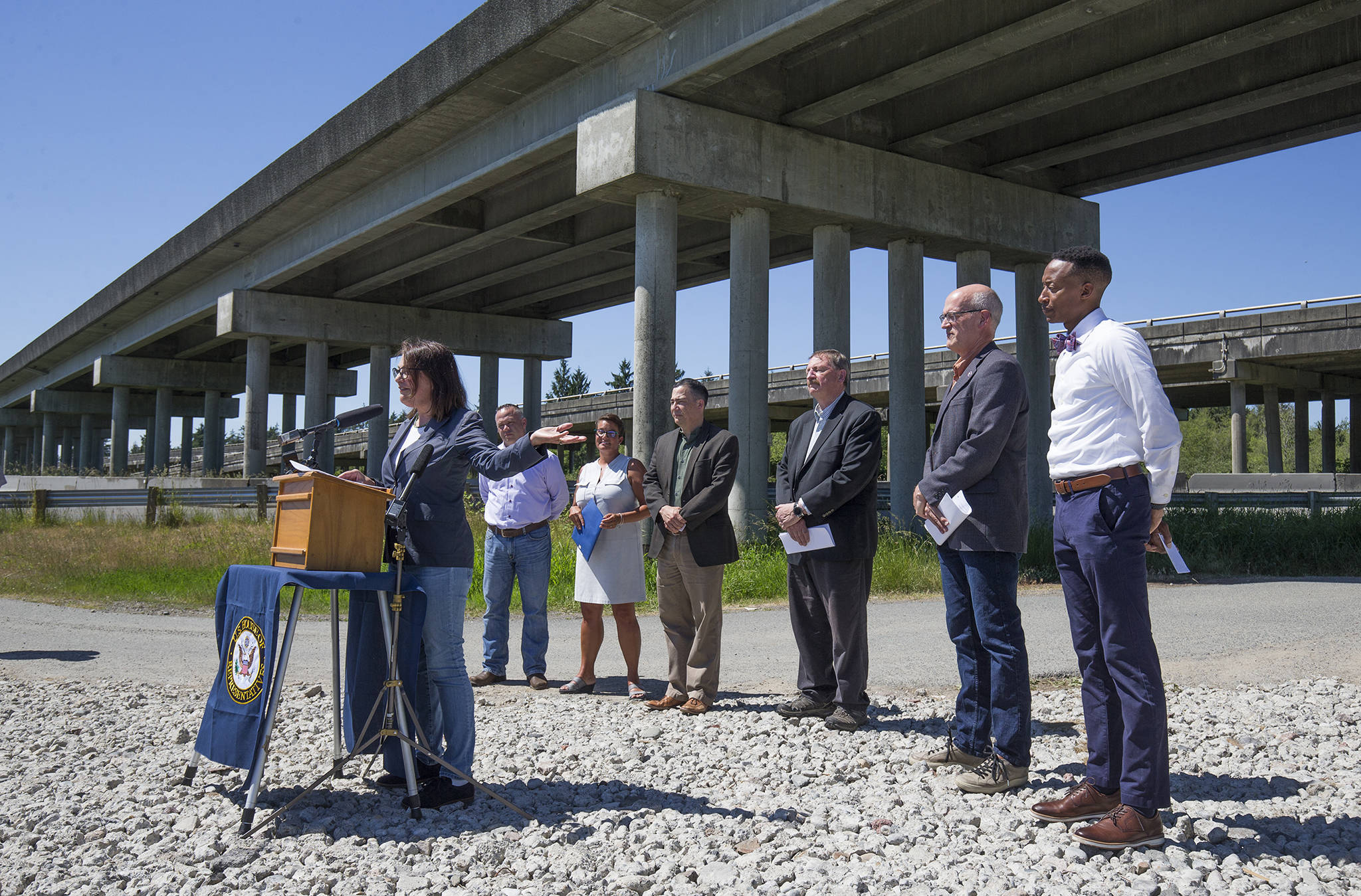 With other officials behind her, U.S. Rep. Suzan DelBene, D-Wash., speaks at a press conference beneath the U.S. 2 trestle, June 2, in Lake Stevens. Elected officials gathered to make their case for how an injection of federal funds into the nation’s transportation infrastructure could lead to less congested and safer commutes for Snohomish County residents. (Andy Bronson / The Herald)
