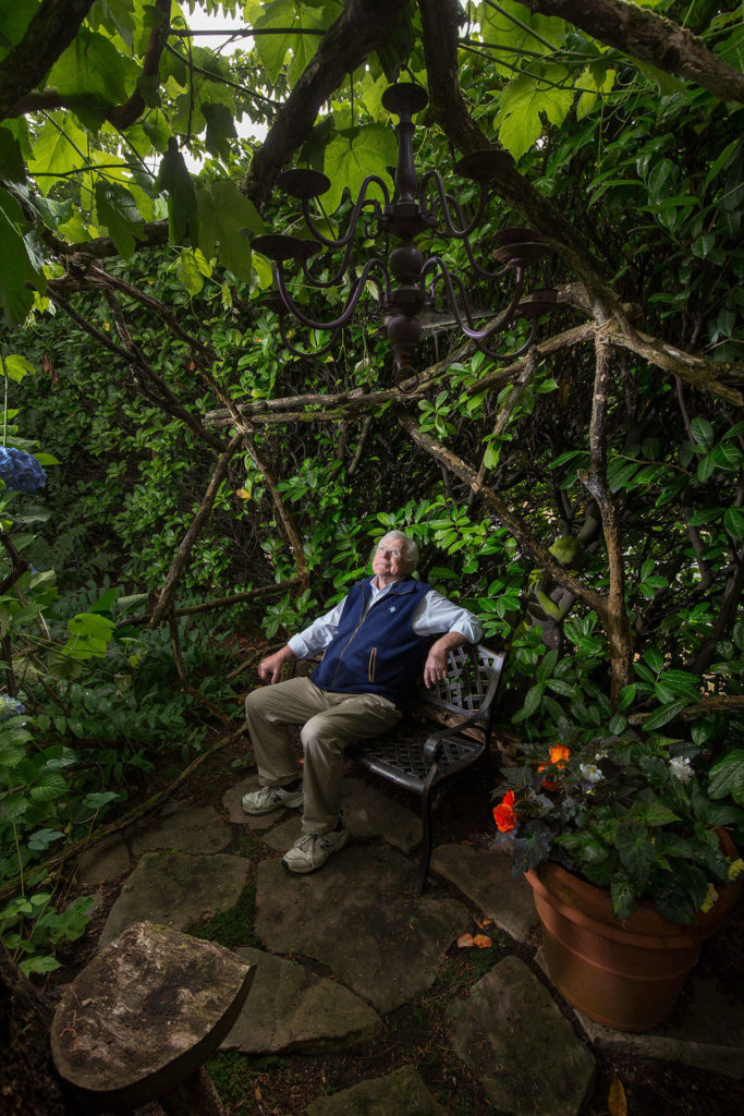 Bill Taylor sits in an area called “Hobbit House” in his garden Tuesday in Edmonds. The Taylor’s home is a stop on the Edmonds in Bloom garden tour to be held on July 18. (Andy Bronson / The Herald)
