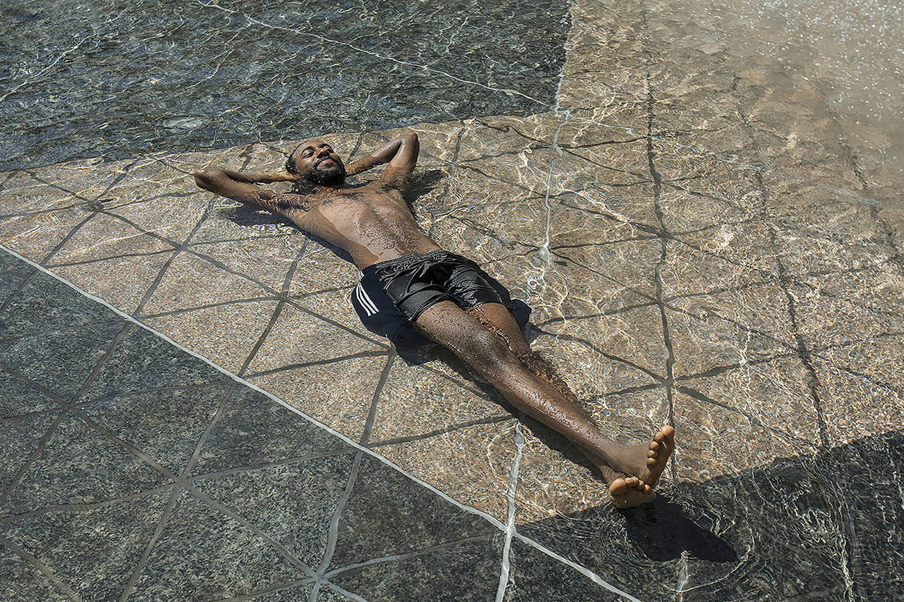 Kais Bothe relaxes in the cool in the city hall pool, as temperatures hit 37 degrees Celsius (98.6 Fahrenheit) in Edmonton, Alberta, on Wednesday, June 30, 2021. (Jason Franson/The Canadian Press via AP)