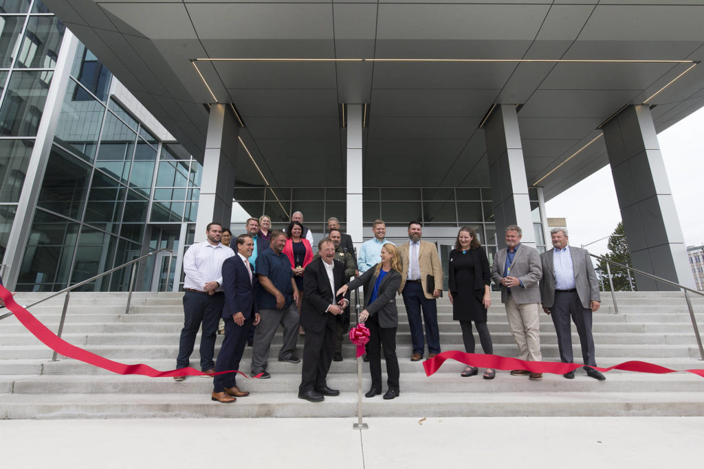 Surrounded by Snohomish County leaders and representatives from labor, construction companies and others, Snohomish County Executive Dave Somers and County Council Chair Stephanie Wright cut a ribbon to mark the completion of the Snohomish County Courthouse remodel and addition project Thursday in Everett. (Andy Bronson / The Herald)
