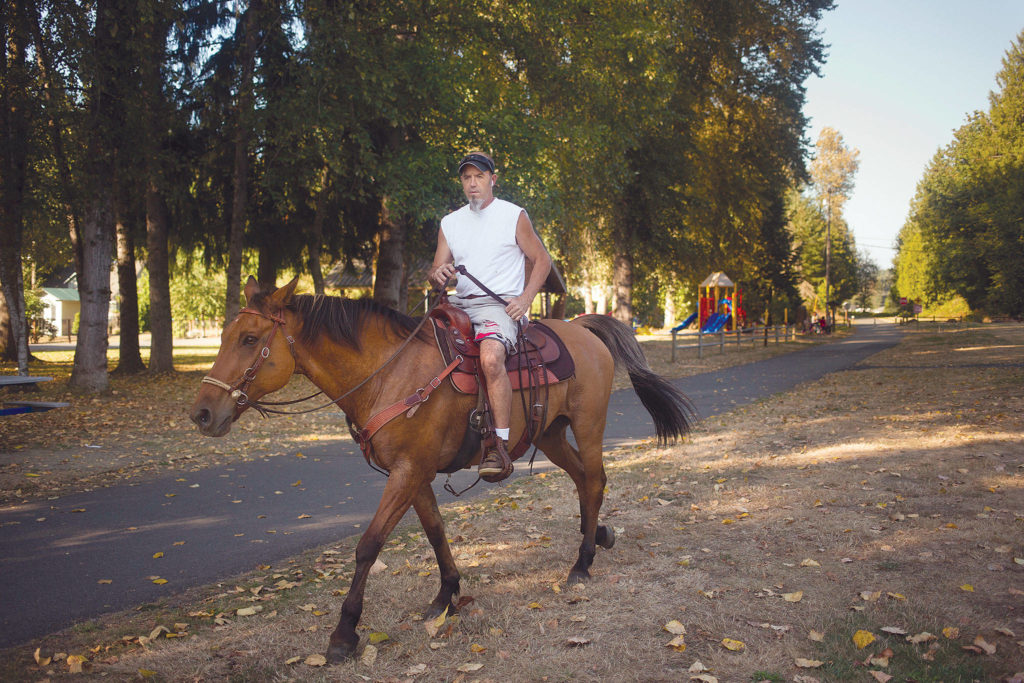 Chuck Denny heads out on his quarter horse, Kona, from the Machias Trailhead. (Andy Bronson / The Herald)
