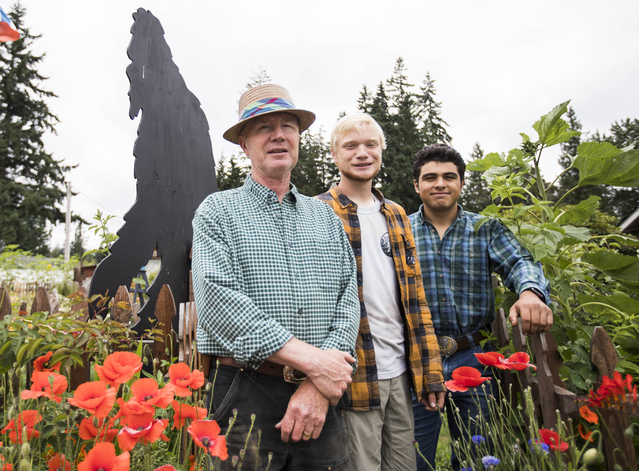 Joseph Lindell (left), his son Nathaniel, 19 (center), and Jason Guzman, 18, stand next to the Bigfoot cutout on Beverly Lane in Everett. Nathaniel made several Bigfoot cutouts during the pandemic to stay busy. He and Guzman, both 2021 Cascade High School graduates, leave in September on the U.S. Marine Corps buddy program. (Olivia Vanni / The Herald)