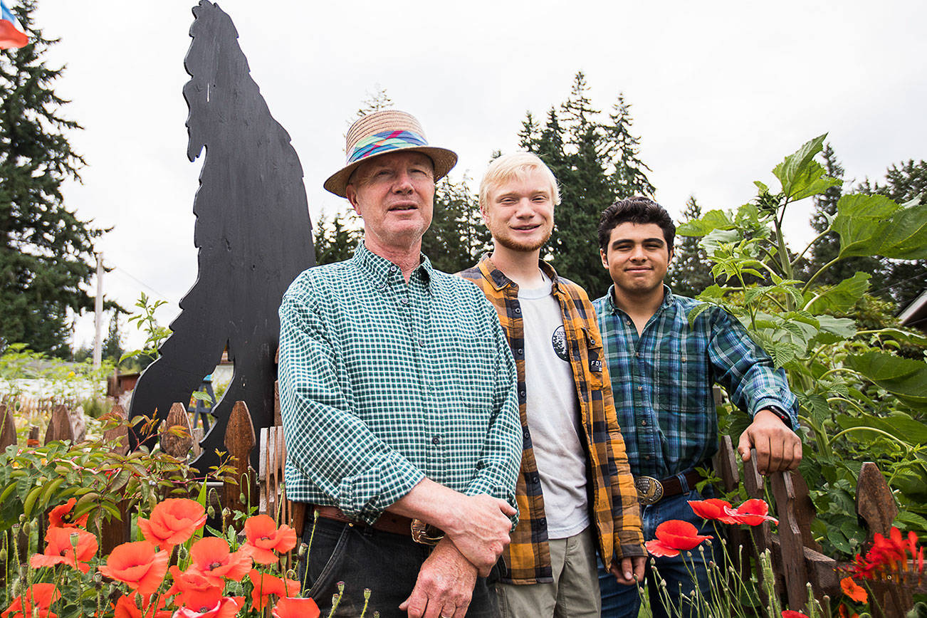 Joseph Lindell, left, Nathaniel Lindell, 19 and Jason Guzman, 18, next to one of Nathaniel's Bigfoot cutout on Friday, July 16, 2021 in Everett, Wash. (Olivia Vanni / The Herald)