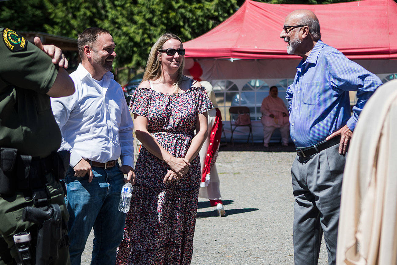 Snohomish County Sheriff Adam Fortney, left and Husaynia Islamic Society of Seattle vice president Masood Zaidi, right, chat at the Eid ul Adha celebration on Saturday, July 24, 2021 in Snohomish, Wash. (Olivia Vanni / The Herald)