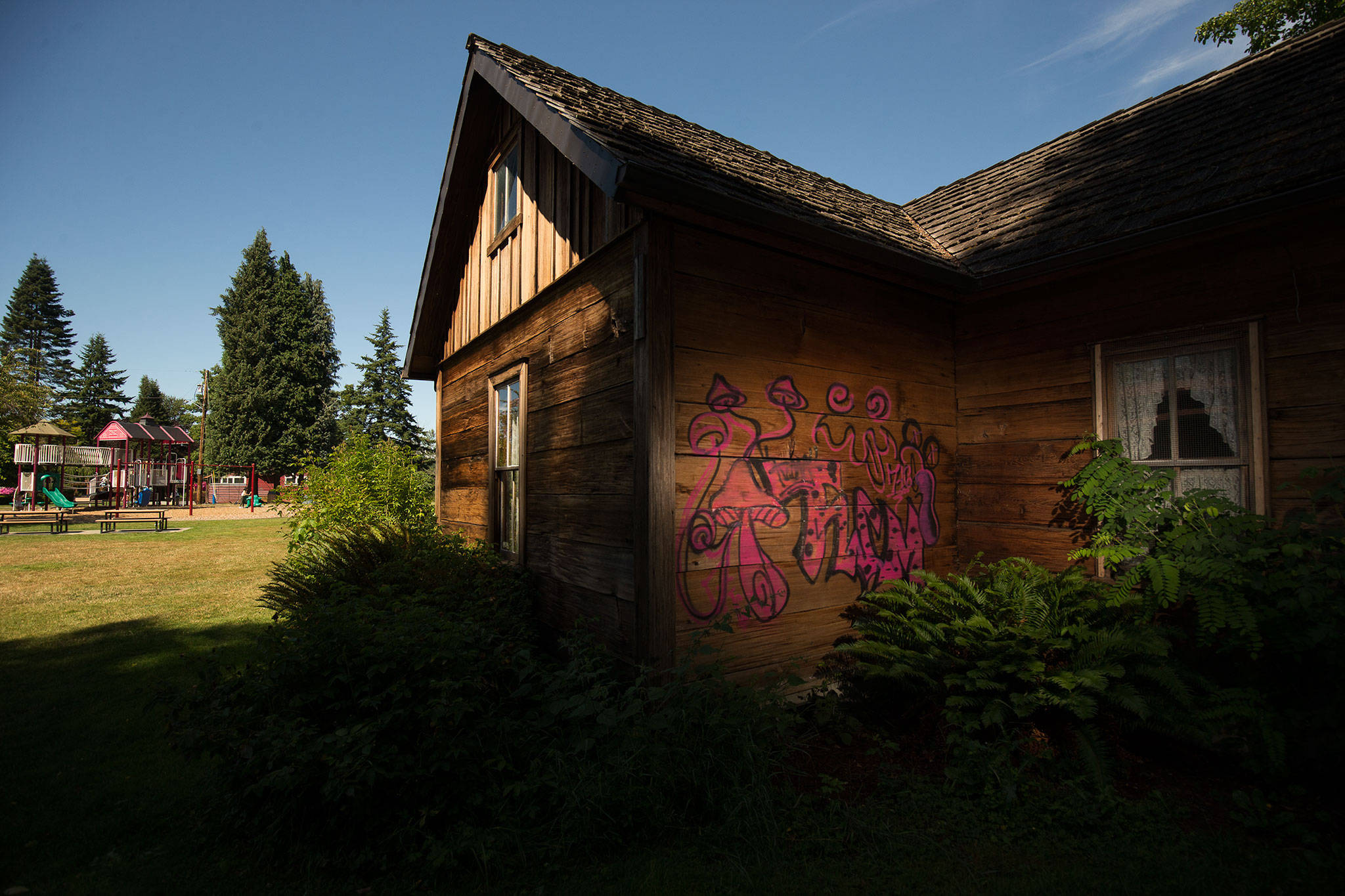 Graffiti can be seen on the back walls of the Pioneer Gehl House in Jennings Memorial Park in Marysville. (Andy Bronson / The Herald)