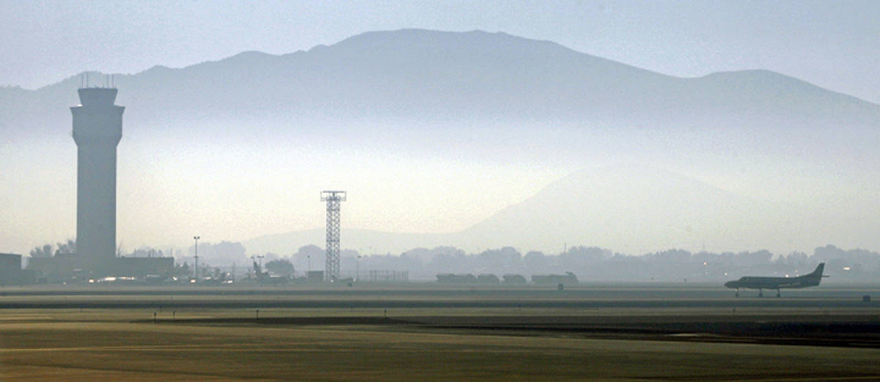 In this 2014 photo, smoke hangs over Reno-Tahoe International Airport as a plane takes off. A shortage of jet fuel, coupled with supply chain issues and an urgent demand from firefighting aircraft, continues to cause problems at airports around the West. (AP Photo/Martha Irvine, File)