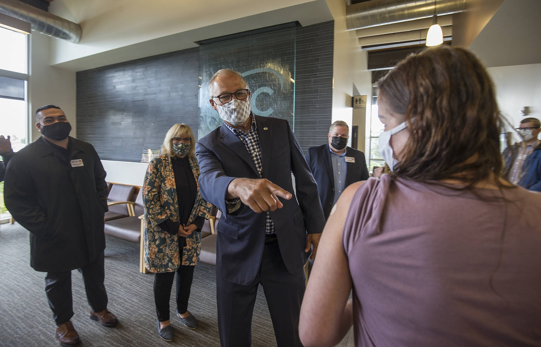 Gov. Jay Inslee points at the Band-Aid on Florence Montgomery’s arm after she got her second vaccine shot at the Community Health Centers of Snohomish County in Edmonds on June 7. (Andy Bronson / Herald file)