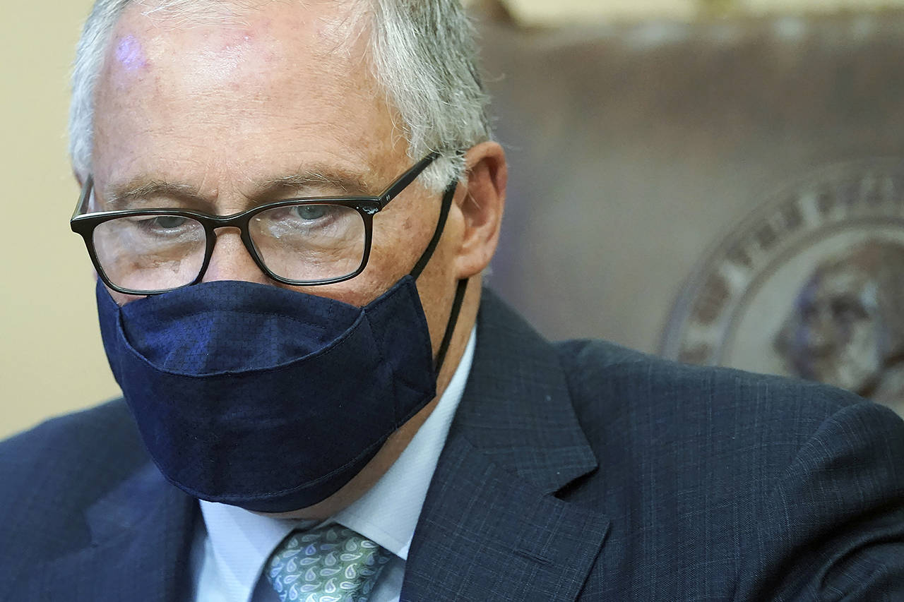A masked Gov. Jay Inslee is seen May 12 at the Capitol in Olympia. The governor is now asking everyone — vaccinated or not — to consider wearing a mask in crowded indoor settings. (AP Photo/Ted S. Warren, file)