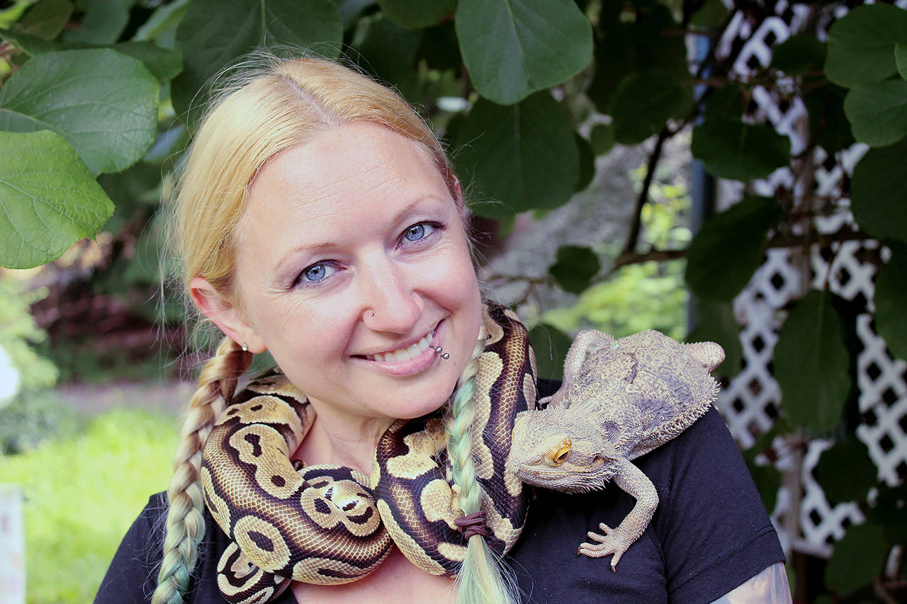 Amanda Ferrara poses with ball python Lemon and bearded dragon Drogon. (Karina Andrew / Whidbey News-Times)