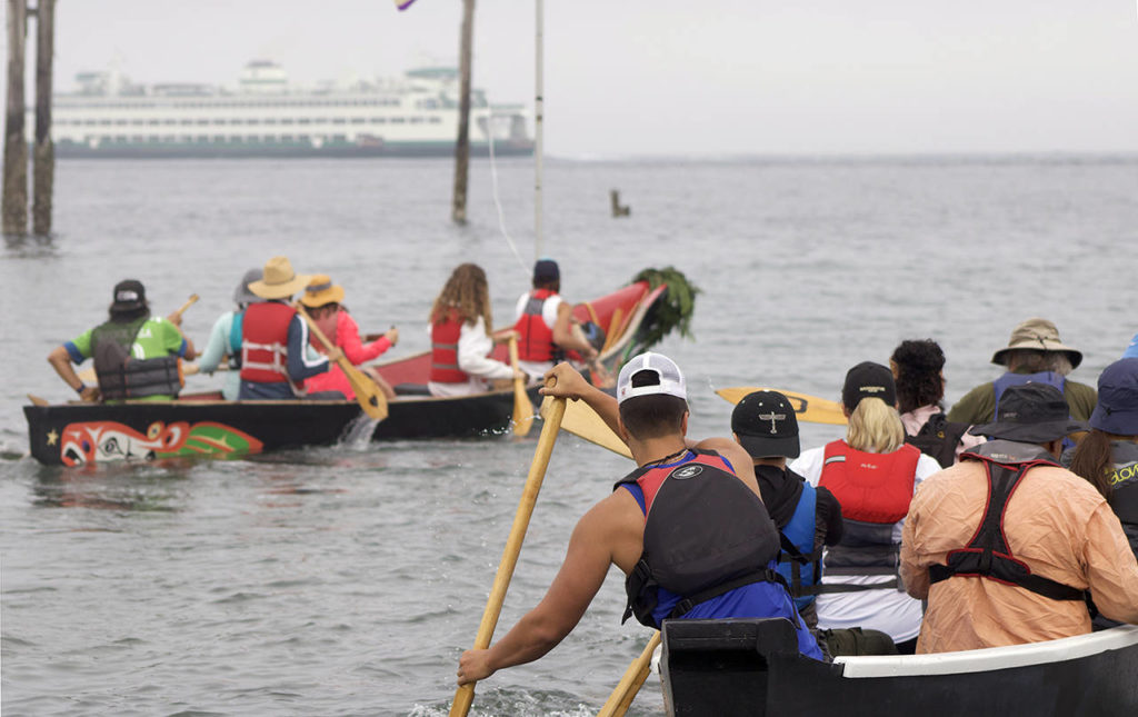 Members of the Blue Heron Canoe Family paddle away from the Edmonds waterfront to begin their two week journey to Lummi Island. (Isabella Breda / The Herald)
