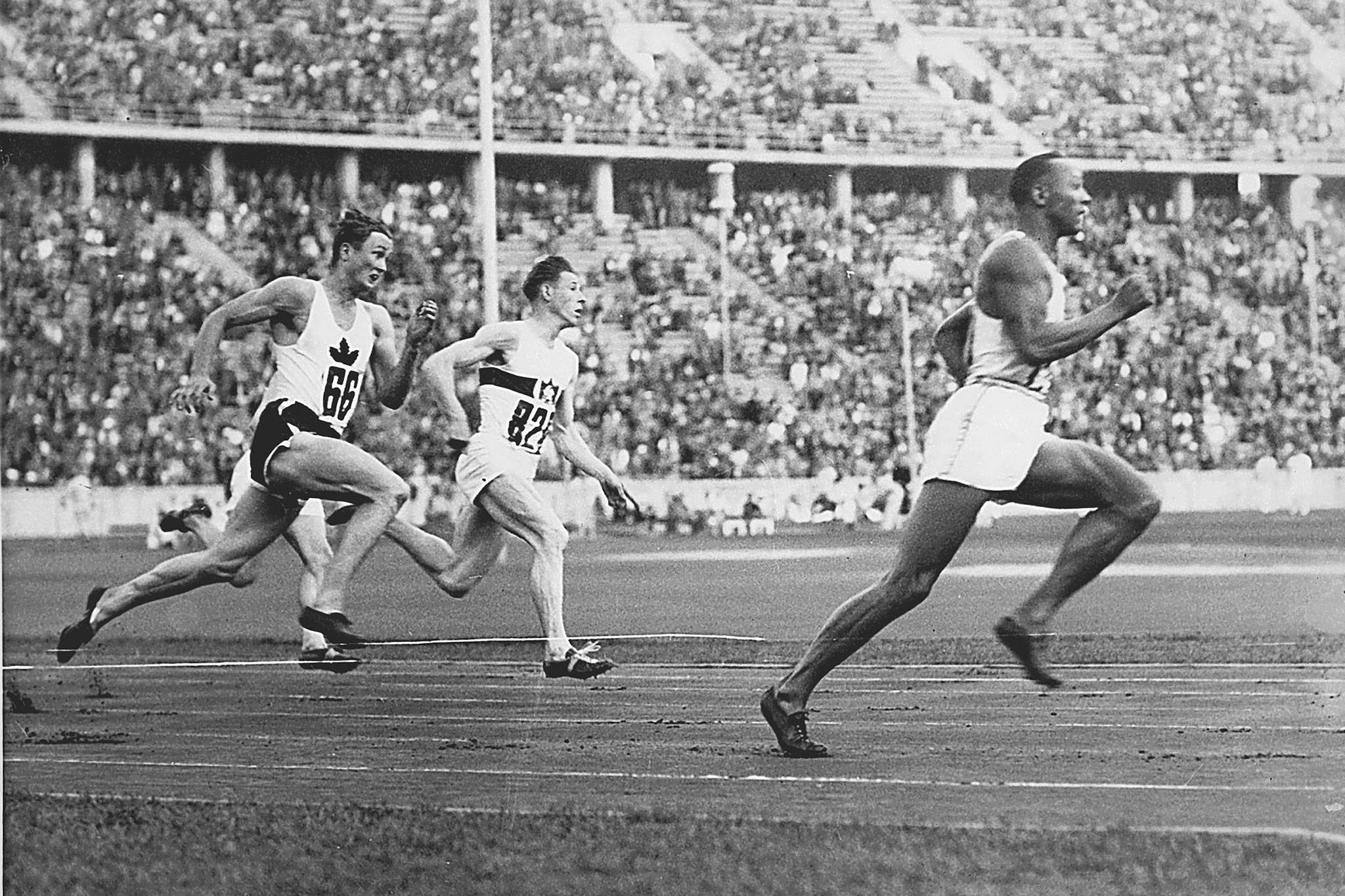 In this 1936 photo, Jesse Owens leads the race during heat 3 of the 200-meter quarterfinal, with Lee Orr (left) of Canada and Karl Neckermann of Germany close behind. (Monroe Historical Society)