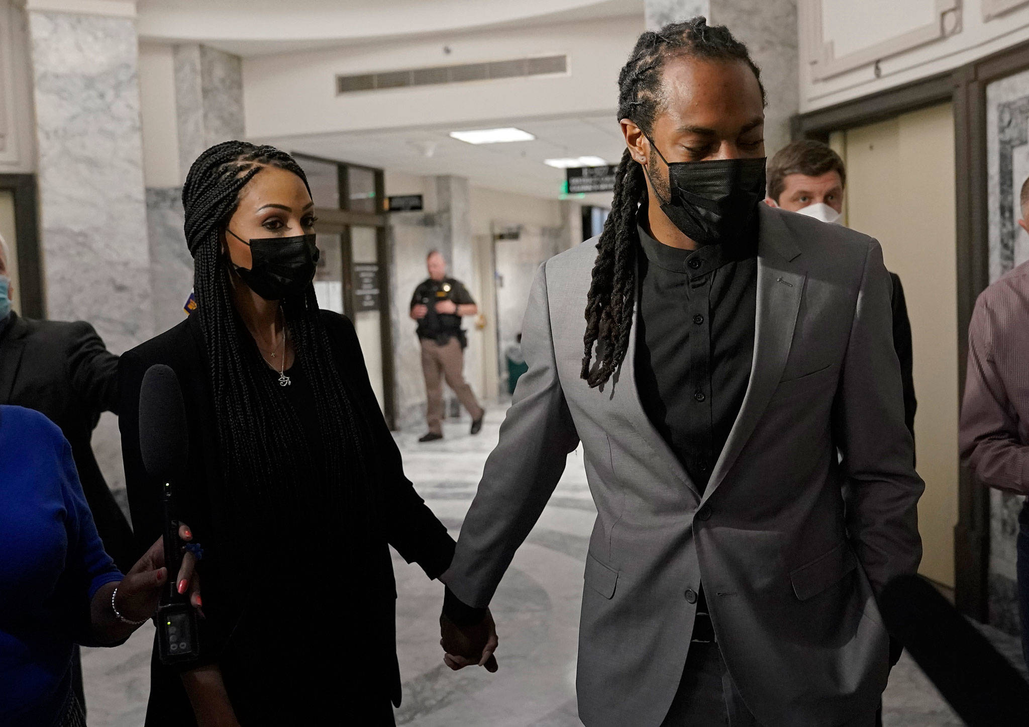 Richard Sherman (right) holds hands with his wife, Ashley, following a King County District Court hearing on July 16, 2021, in Seattle. (AP Photo/Ted S. Warren)