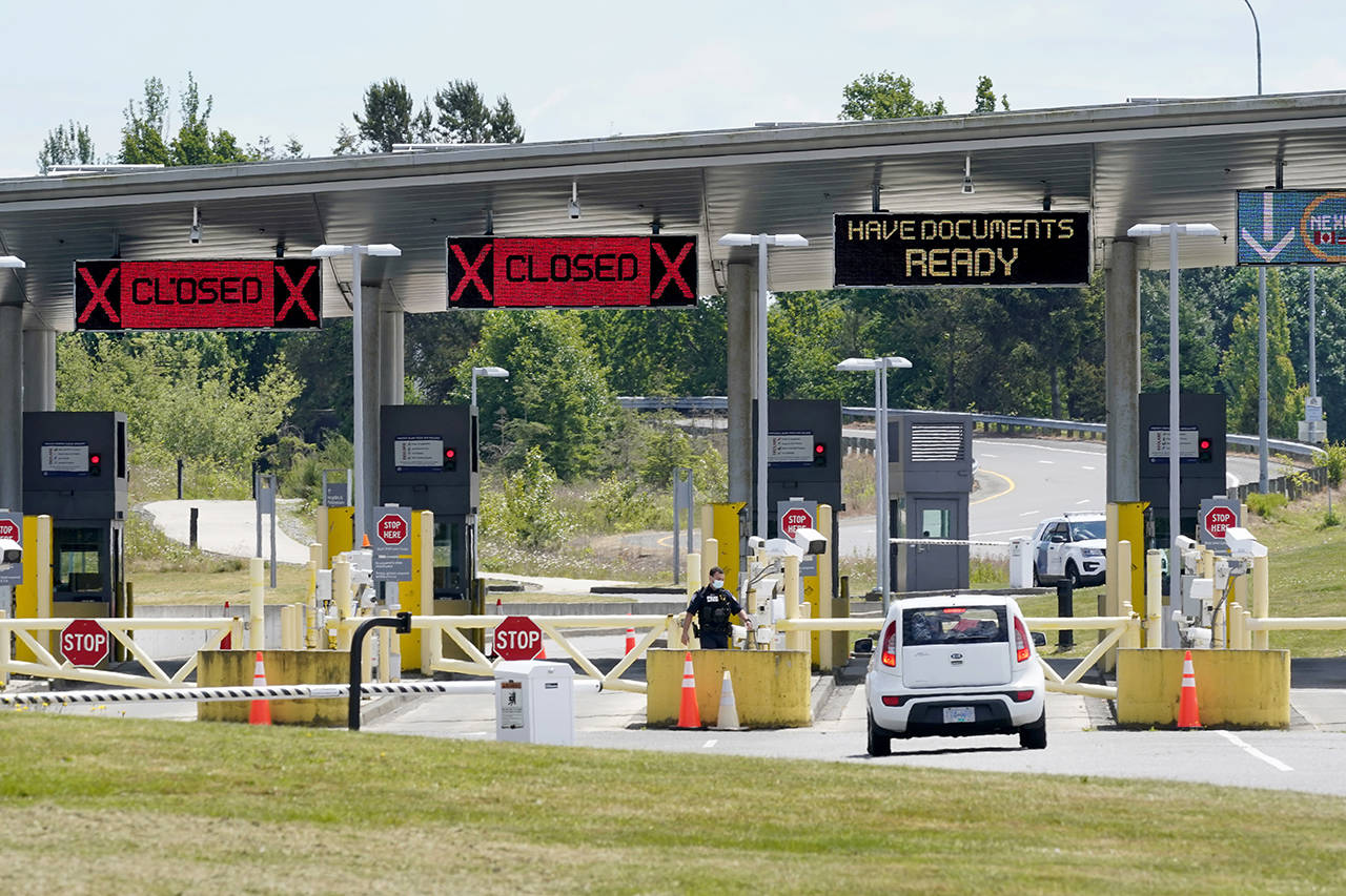 In this June 8 photo, a car approaches one of the few lanes open at the Peace Arch border crossing into the U.S. in Blaine. (AP Photo/Elaine Thompson, File)