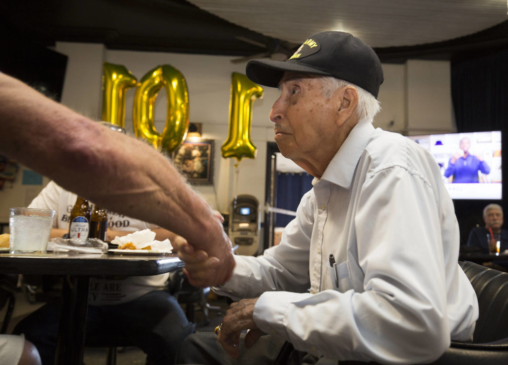 Veteran Larry Negrette, 101, gets a handshake from a fellow service member as the Everett VFW Post hosted a birthday party for him on Tuesday in Everett. (Andy Bronson / The Herald) 
