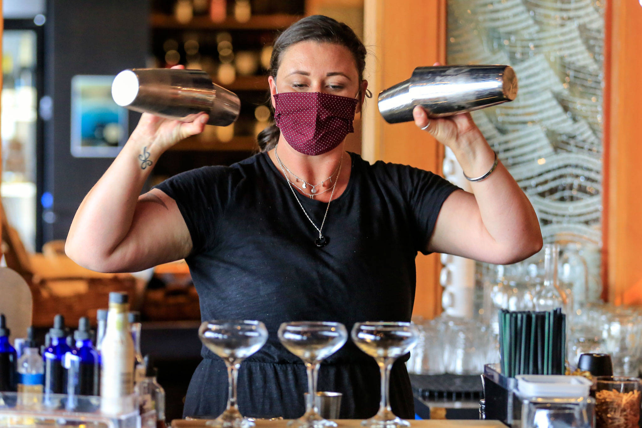 Madison Bauer mixes drinks at Bluewater Organic Distilling in Everett. (Kevin Clark / The Herald)