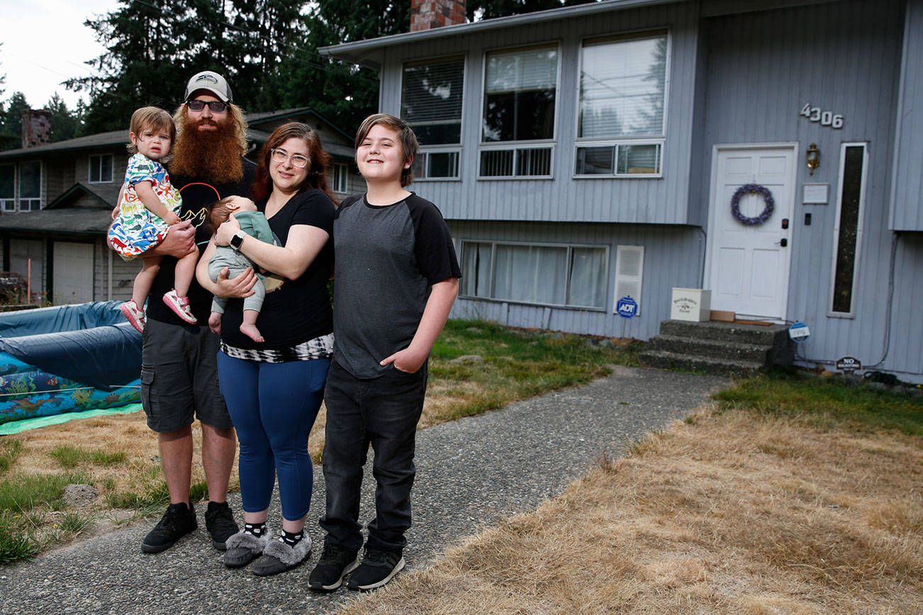 Matt Mosteller holding Montana Mosteller (left-right) Lindsay Mosteller holding Sequoia Mosteller and Steven Hailey were forced to sell their home to the county for a project that widens 43rd Avenue in Bothell.  (Kevin Clark / The Herald)