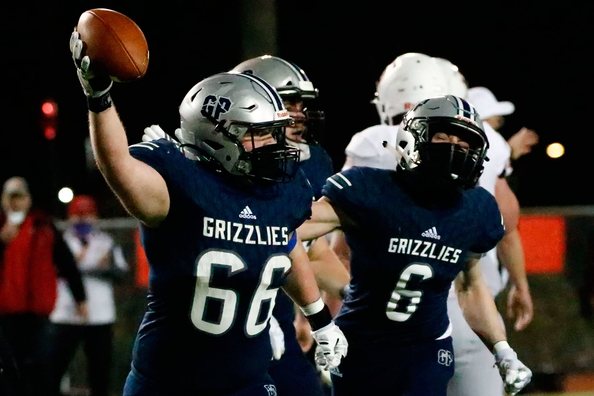 Glacier Peak’s Adam Troxel celebrates a fumble recovery with teammate Jackson Hawkins at Veterans Memorial Stadium in Snohomish on March 12. (Kevin Clark / The Herald)