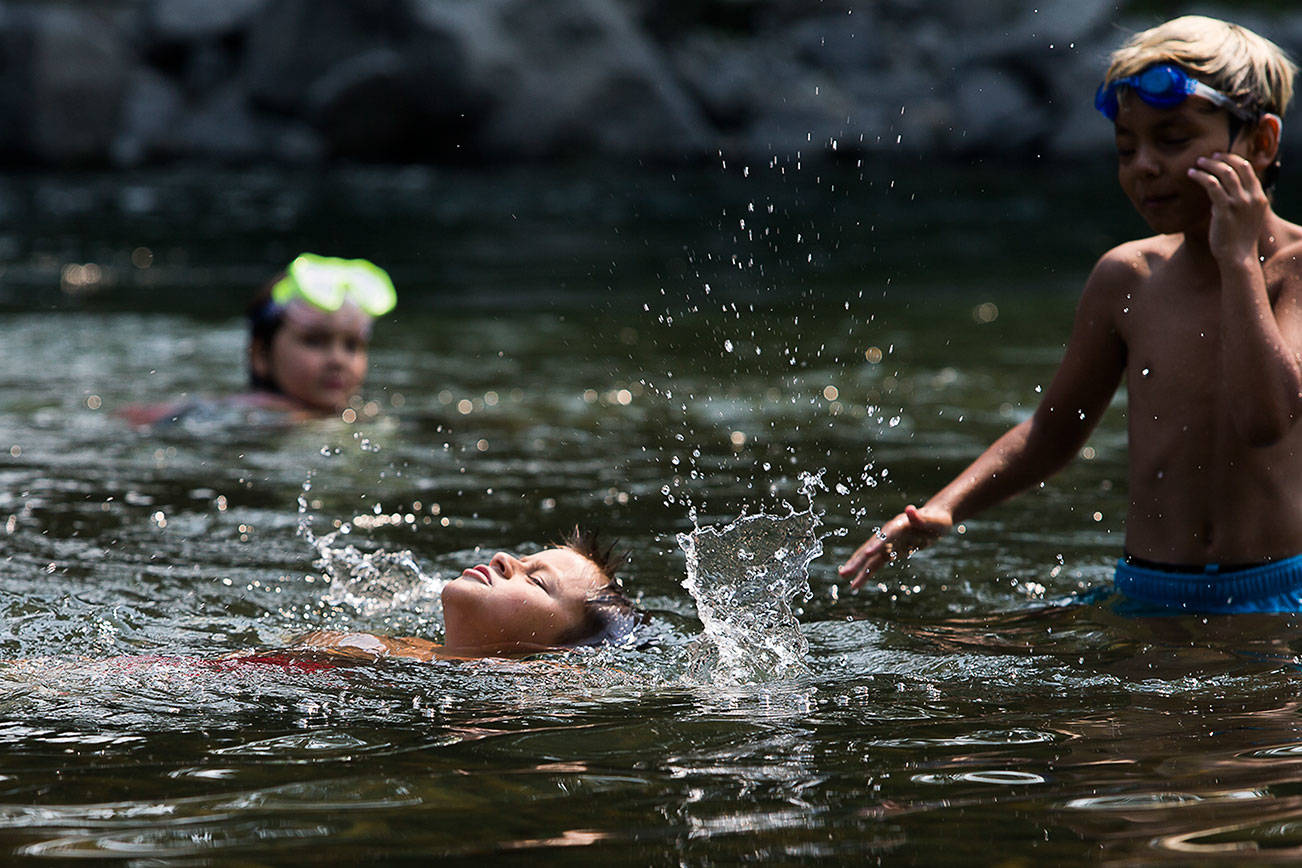 Lightning Powers, 8, splashes as he comes up for air while swimming in the South Fork Stillaguamish River on Friday, Aug. 13, 2021 in Arlington, Wash. (Olivia Vanni / The Herald)