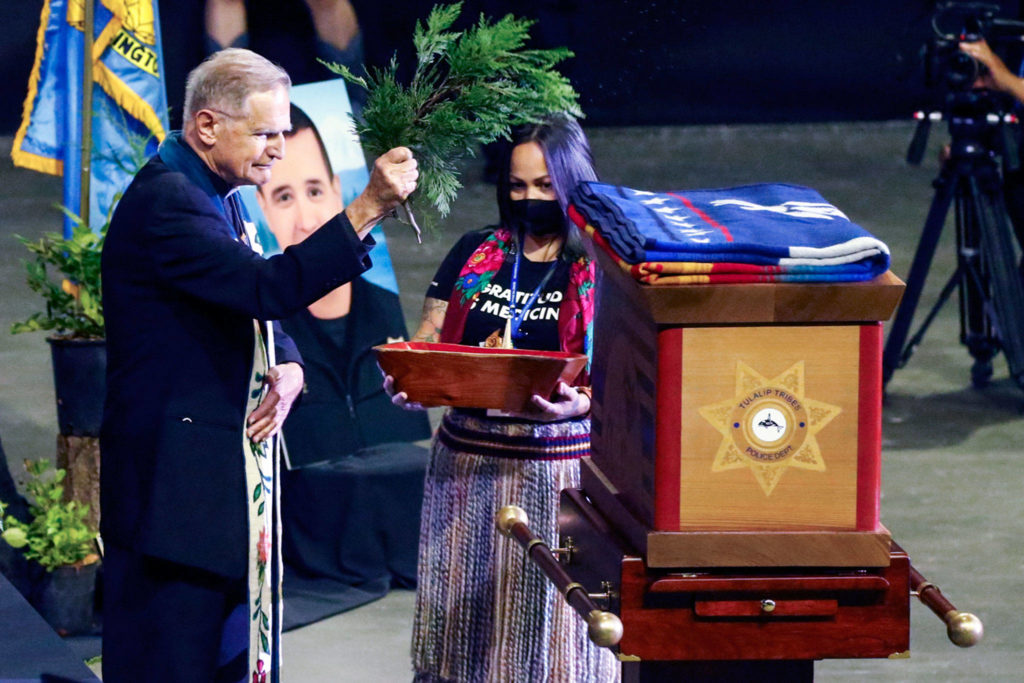 Father Pat Twohy performs a blessing for Officer Charlie Joe Cortez on Tuesday at Angel of the Winds Arena in Everett. (Kevin Clark / The Herald)
