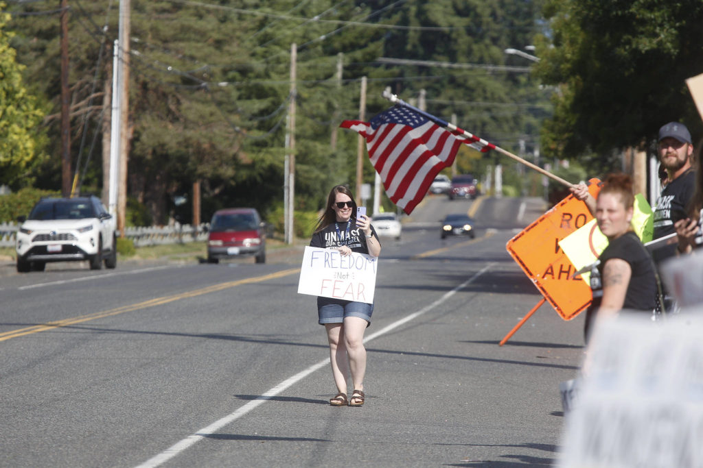 Protesters gather in front of the Marysville School District office on Wednesday to voice their anger over mask mandates in schools. (Andy Bronson / The Herald)
