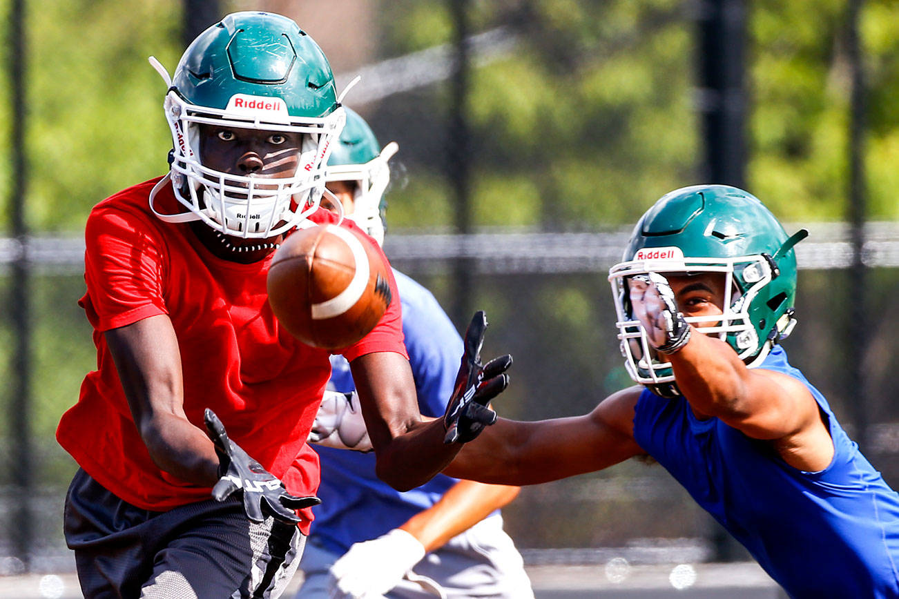 Ruot Deng makes a reception with Nathaniel Marinez defending during practice at Thursday afternoon at Edmonds-Woodway High School in Edmonds on August 19, 2021.  (Kevin Clark / The Herald)