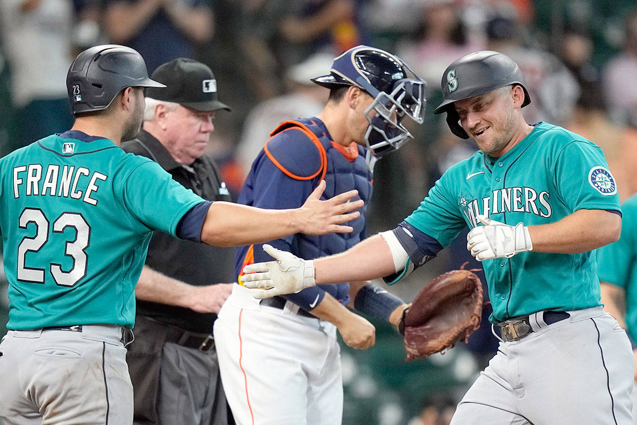 Seattle Mariners’ Kyle Seager, right, celebrates with Ty France (23) after both scored on Seager’s three-run home run against the Houston Astros during the 11th inning of a game Sunday in Houston. (AP Photo/David J. Phillip)