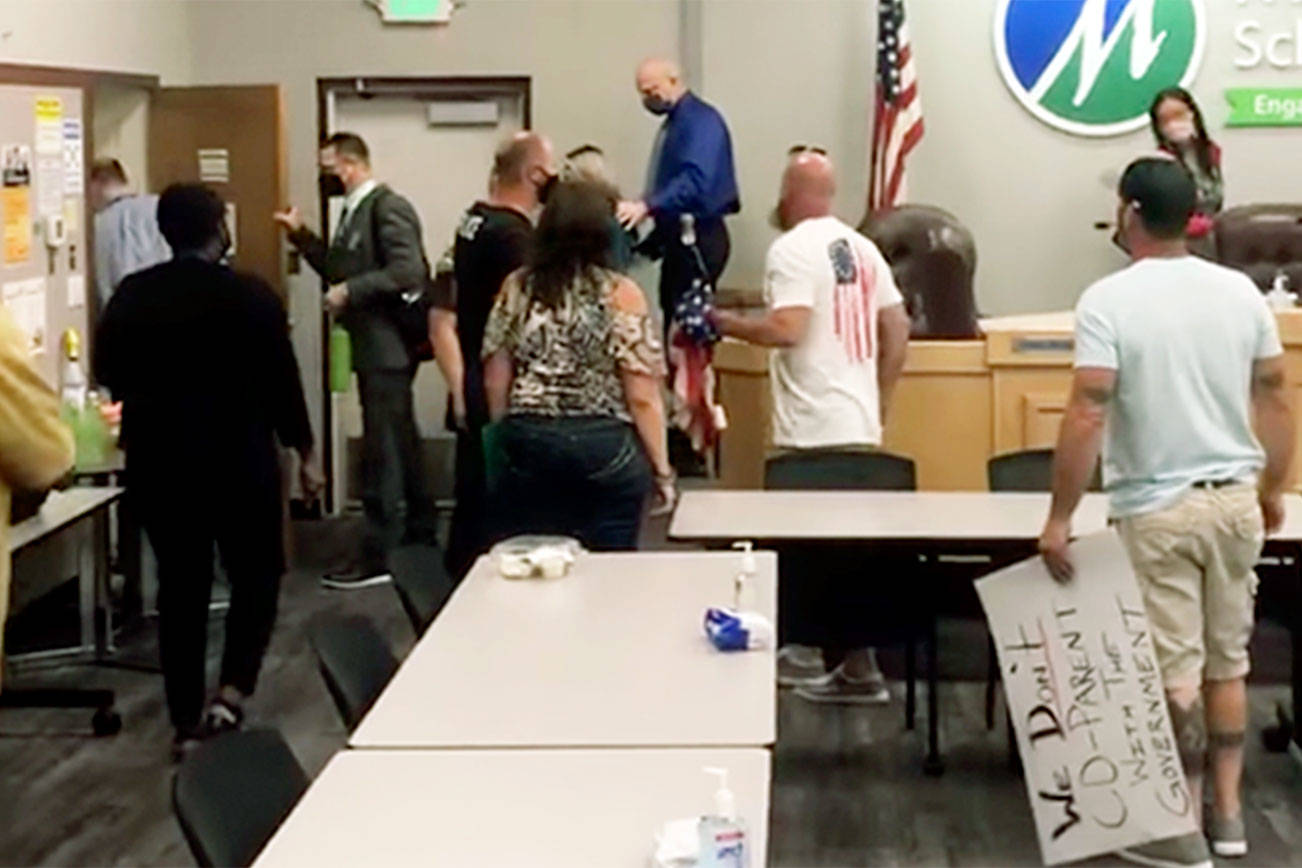 Members of the Marysville School Board leave a meeting on Aug. 18 as anti-mask protesters heckle them. (Jeremy Milam via Facebook) 20210818