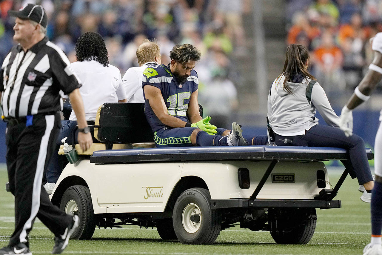 Seattle Seahawks wide receiver John Ursua is taken off the field on a cart after an injury during the first half of the team’s preseason game against the Denver Broncos on Saturday in Seattle. (AP Photo/Stephen Brashear)