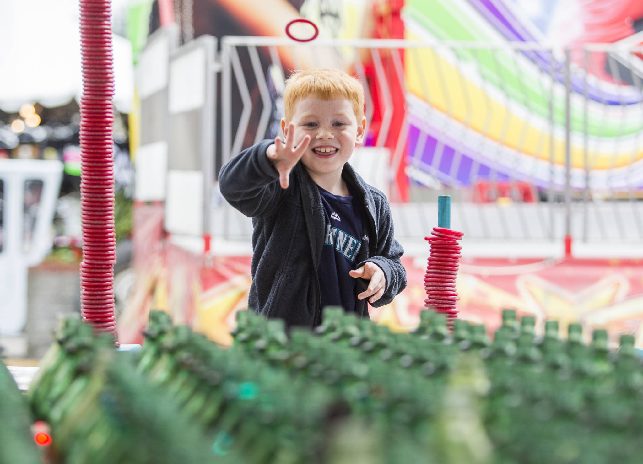 Wyatt Liddle, 7, plays a ring toss game during opening day of the Evergreen State Fair on Thursday in Monroe. (Olivia Vanni / The Herald)
