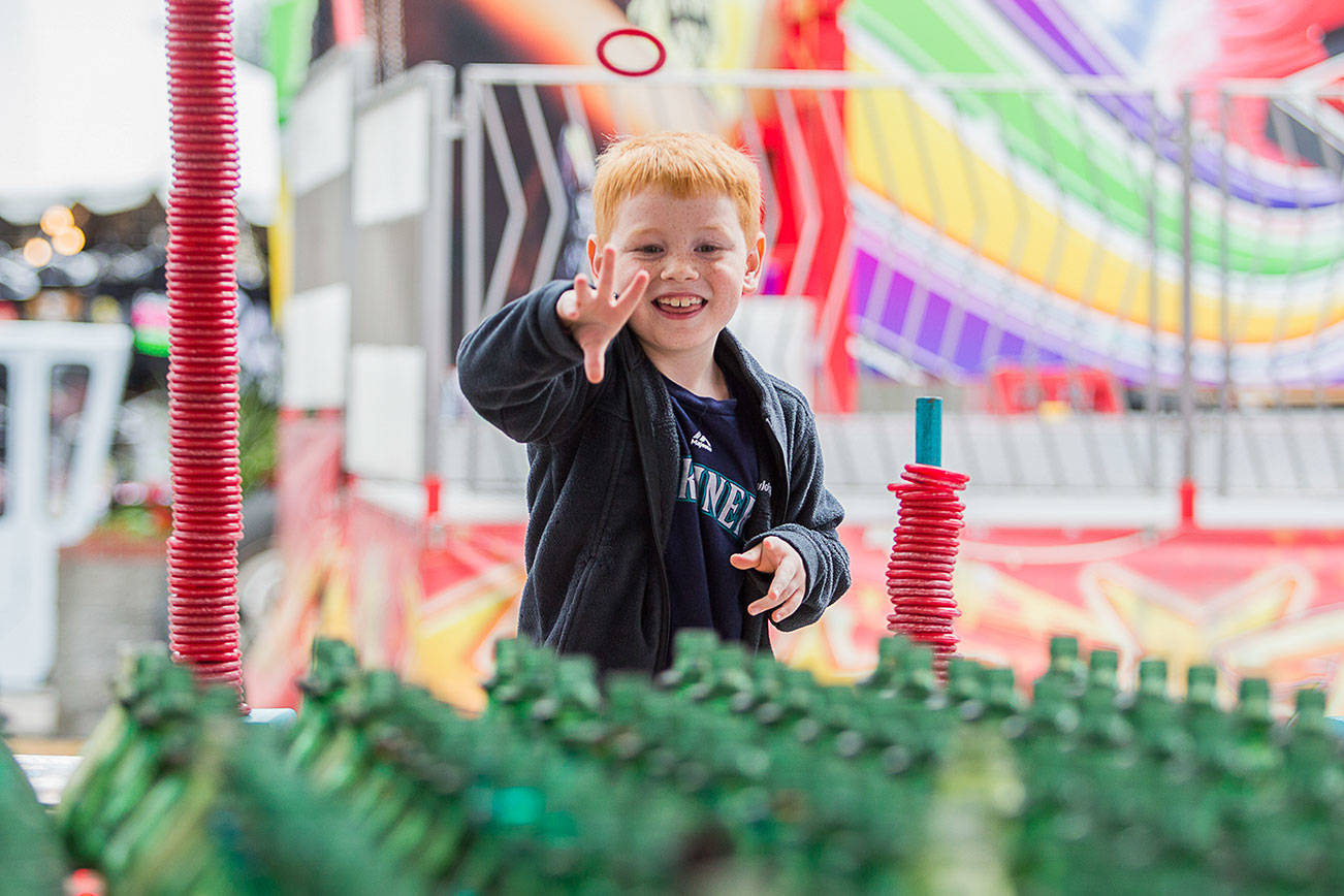 Wyatt Liddle, 7, plays a ring toss game durning opening day of the Evergreen State Fair on Thursday, Aug. 26, 2021 in Monroe, Wash. (Olivia Vanni / The Herald)