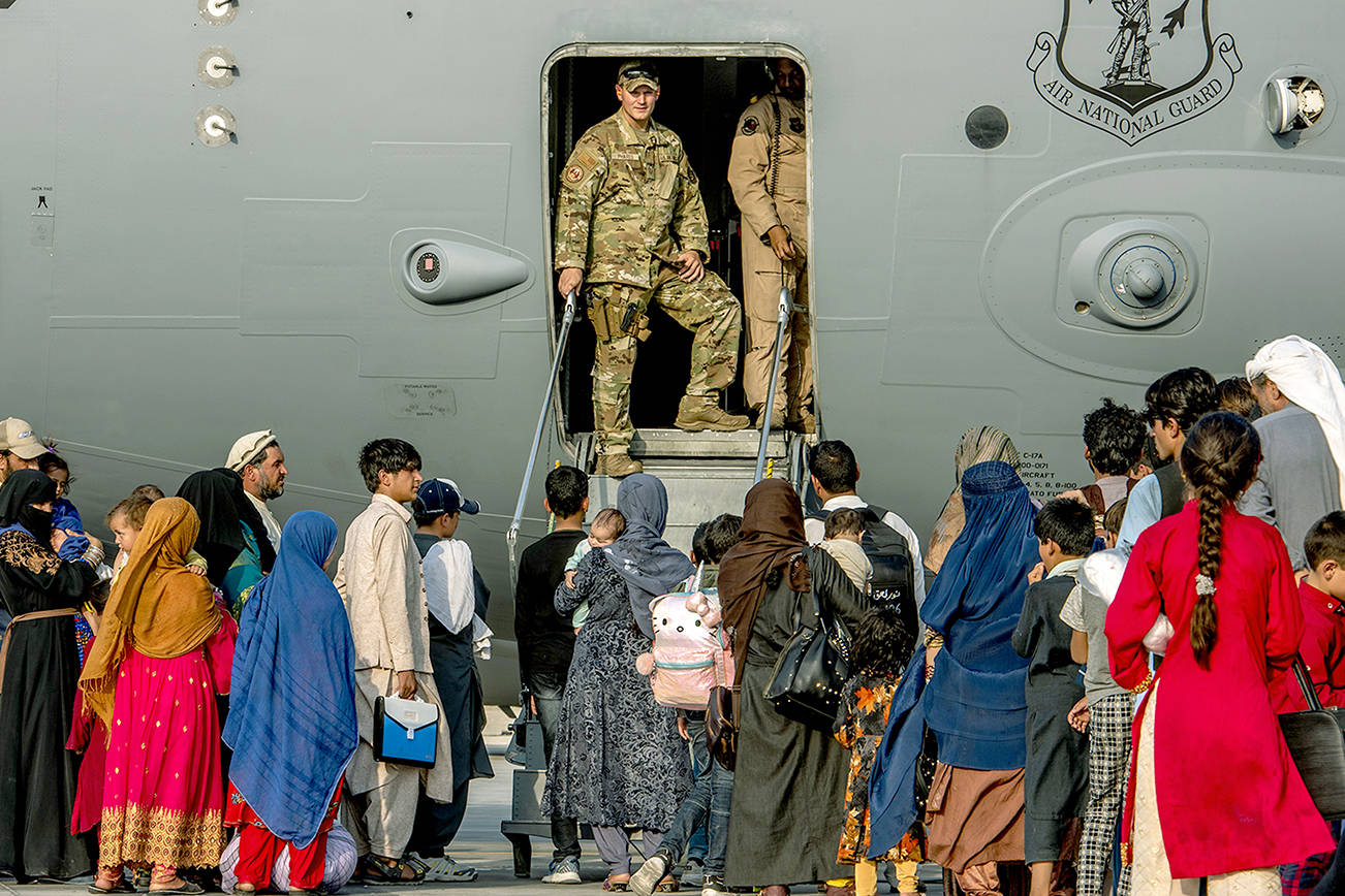 In this Aug. 22, 20121, image provided by the U.S. Air Force, service members prepare to board evacuees onto a C-17 Globemaster lll on Sunday, Aug. 22, 2021, at Al Udeid Air Base, Qatar. The Department of Defense is committed to supporting the U.S. State Department in the departure of U.S. and allied civilian personnel from Afghanistan, and to evacuate Afghan allies to safety. (Airman 1st Class Kylie Barrow/U.S. Air Force via AP)