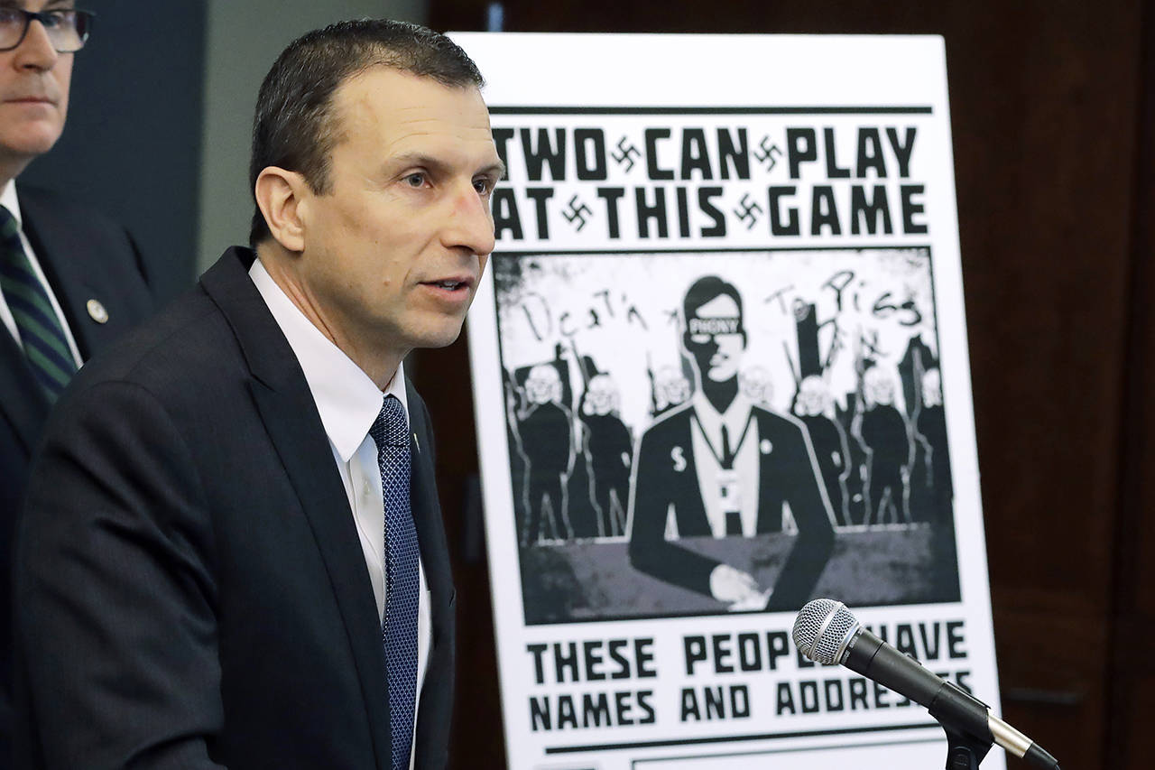 In this 2020 photo, Raymond Duda, then-FBI Special Agent in Charge in Seattle, speaks as he stands next to a poster that was mailed earlier in the year to the home of Chris Ingalls, an investigative reporter with KING-TV in Seattle. (AP Photo/Ted S. Warren, File)