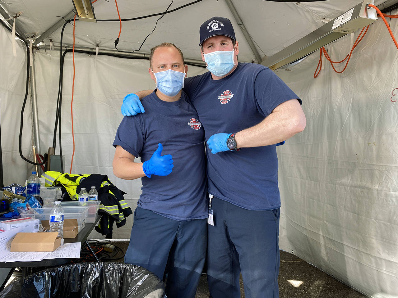 Marysville firefighters Chris Burnette (left) and Chris Lytle were part of the crew vaccinating people at Arlington Municipal Airport in March. The Marysville Fire District was part of the Snohomish County Vaccine Taskforce. (Sue Misao / Herald file)