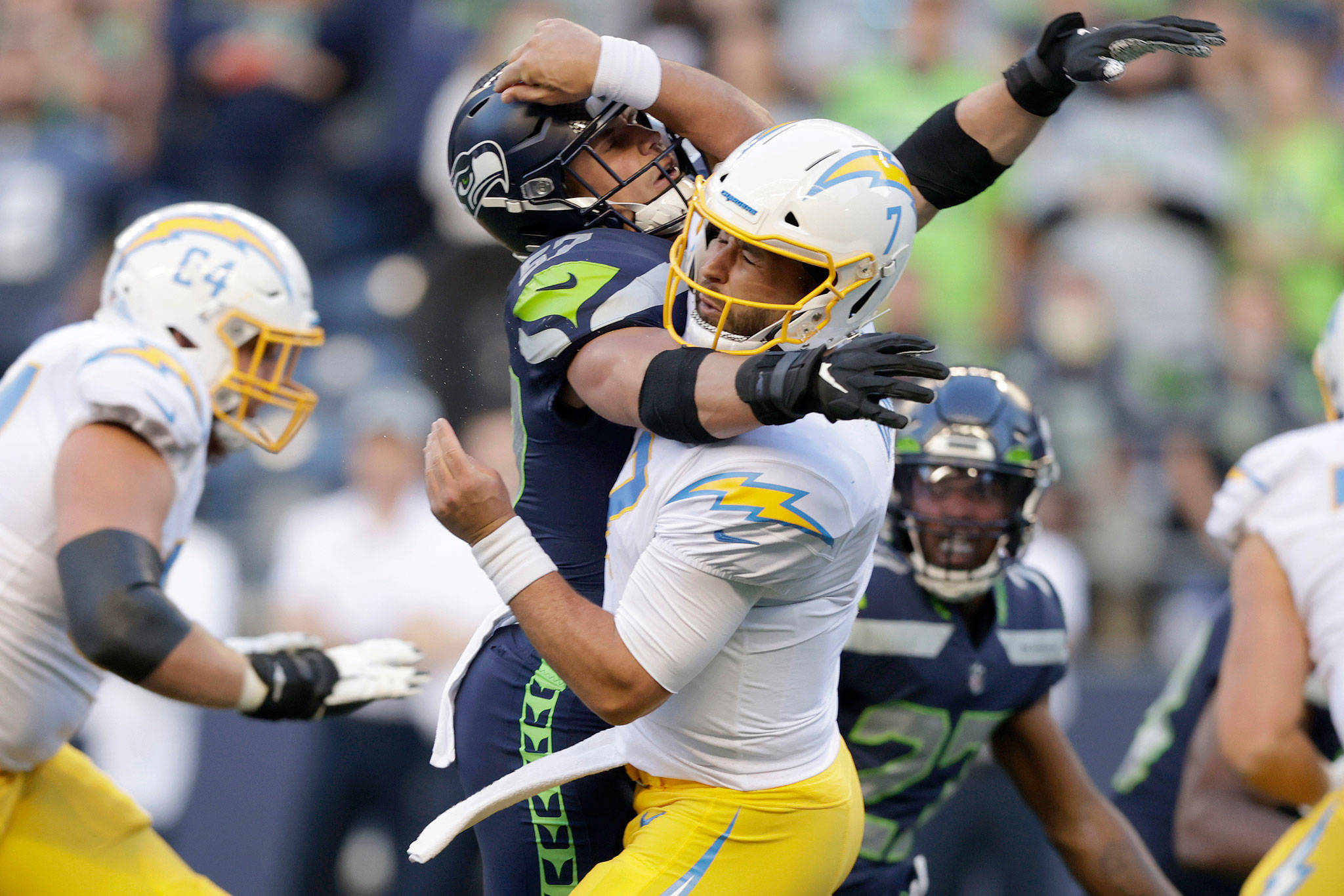 Chargers quarterback Chase Daniel (front right) is hit by Seahawks linebacker Cody Barton, causing a fumble that was recovered by the Seahawks for a touchdown during the first half of a preseason game Aug. 28, 2021, in Seattle. (AP Photo/John Froschauer)