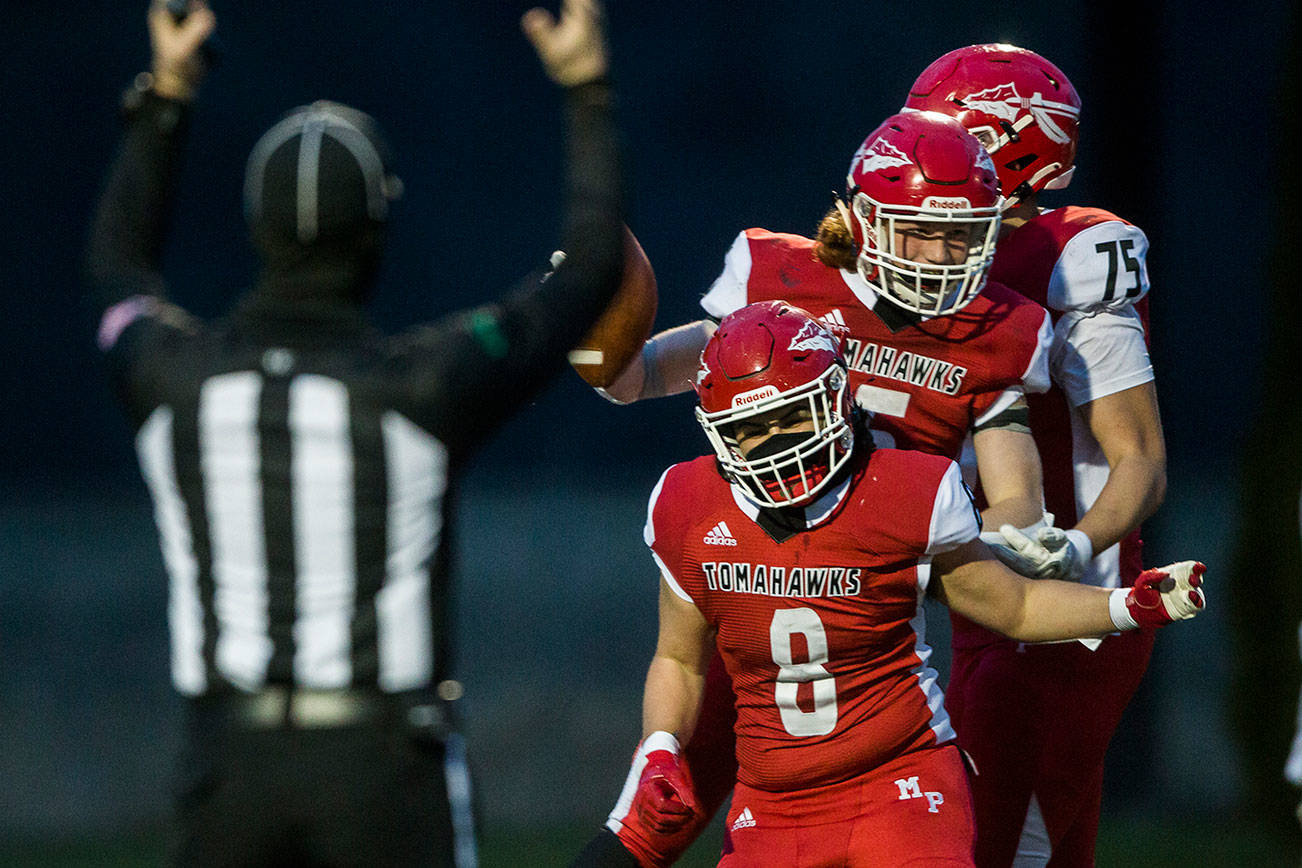 Marysville-Pilchuck’s Kaden Mallang, left, and Kaleb Potts, right, celebrate Dylan Carson’s touchdown during the game on Friday, March 19, 2021 in Marysville, Wa. (Olivia Vanni / The Herald)