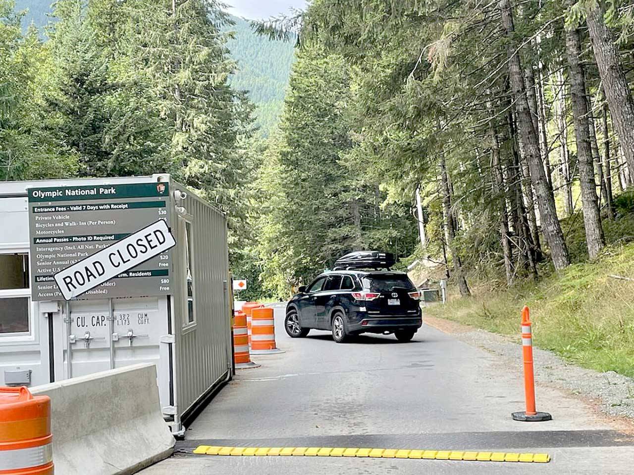A vehicle turns away Monday morning from Olympic National Park’s Heart O’ the Hills entry station after Hurricane Ridge Road was closed due to a suspected armed man fleeing into the woods. (Paul Gottlieb / Peninsula Daily News)