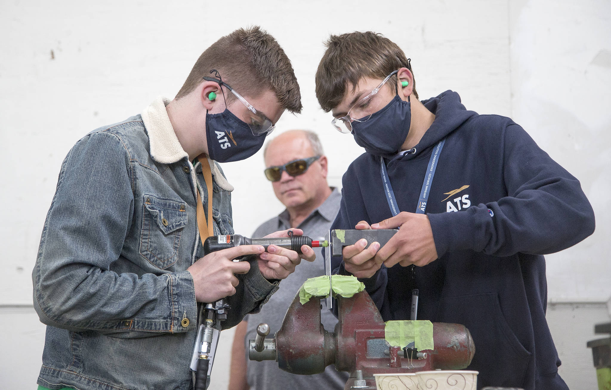 Darby O’Neil (left) and Stan Ryakhovskiy practice riveting while apprentice instructor John Kraft watches. Aviation Technical Services, which repairs and overhauls passenger jets for major airlines, offers an 18-month apprenticeship during which participants are paid to become aircraft mechanics. (Andy Bronson / The Herald)