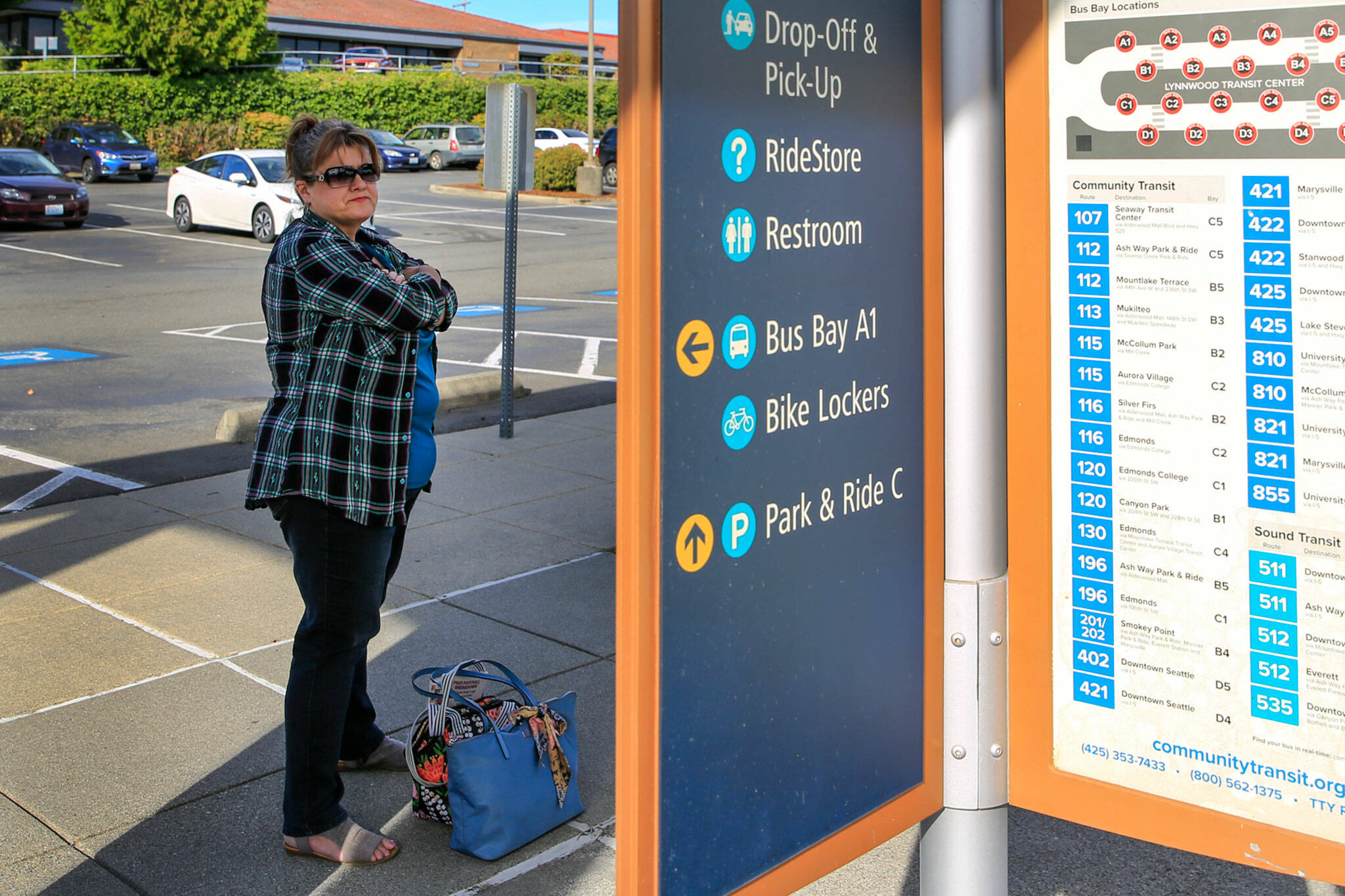 Heather Van Slageren waits for a Community Transit bus to Stanwood at the Lynnwood Transit Center on Wednesday. (Kevin Clark / The Herald)