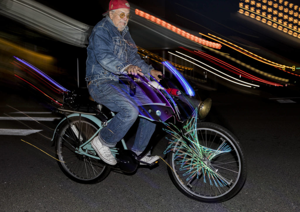 Reggie Miles rides his illuminated bike down Colby Avenue on Saturday in Everett. (Olivia Vanni / The Herald)
