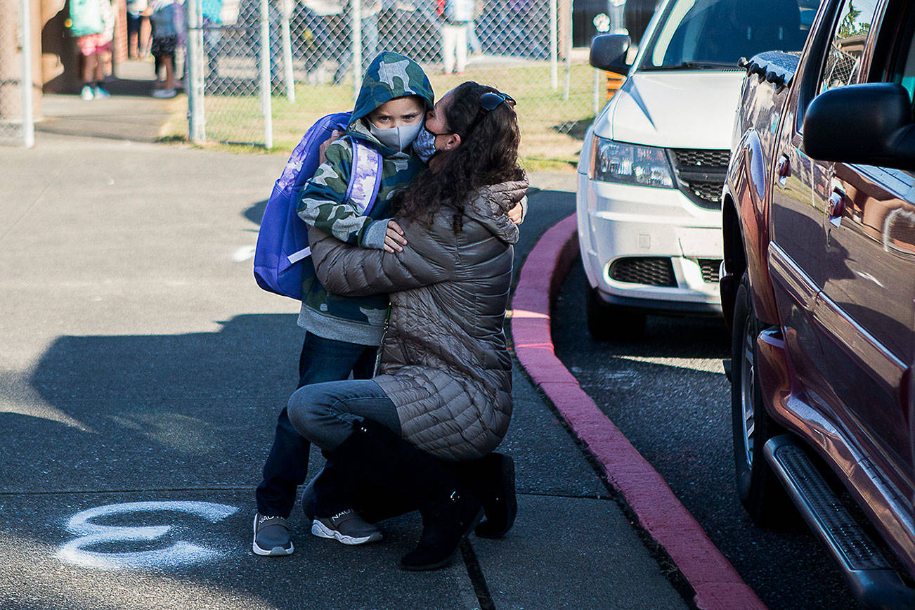 Elizabeth Panagos kisses her son Paxton through her mask as she drops him off for his first day of kindergarten at Mountain Way Elementary on Wednesday, Sept. 1, 2021 in Granite Falls, Wa. (Olivia Vanni / The Herald)