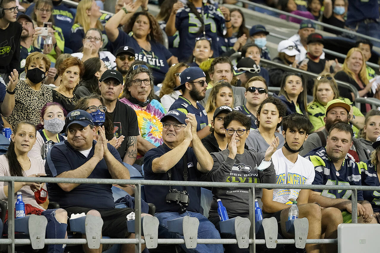 Fans, most without masks, cheer at Seattle’s Lumen Field during the Aug. 28 preseason game between the Seahawks and the Los Angeles Chargers. That will change Sept. 7, when a mask mandate for large outdoor events begins. (AP Photo/Elaine Thompson, file)