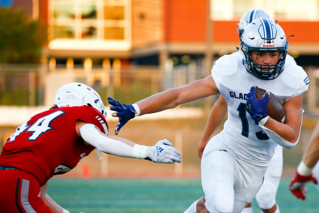 Glacier Peak’s Trey Leckner rushes with Snohomish’s Kaden Alexander attempting a tackle Friday night at Veteran’s Memorial Stadium in Snohomish September 3, 2021. (Kevin Clark / The Herald)
