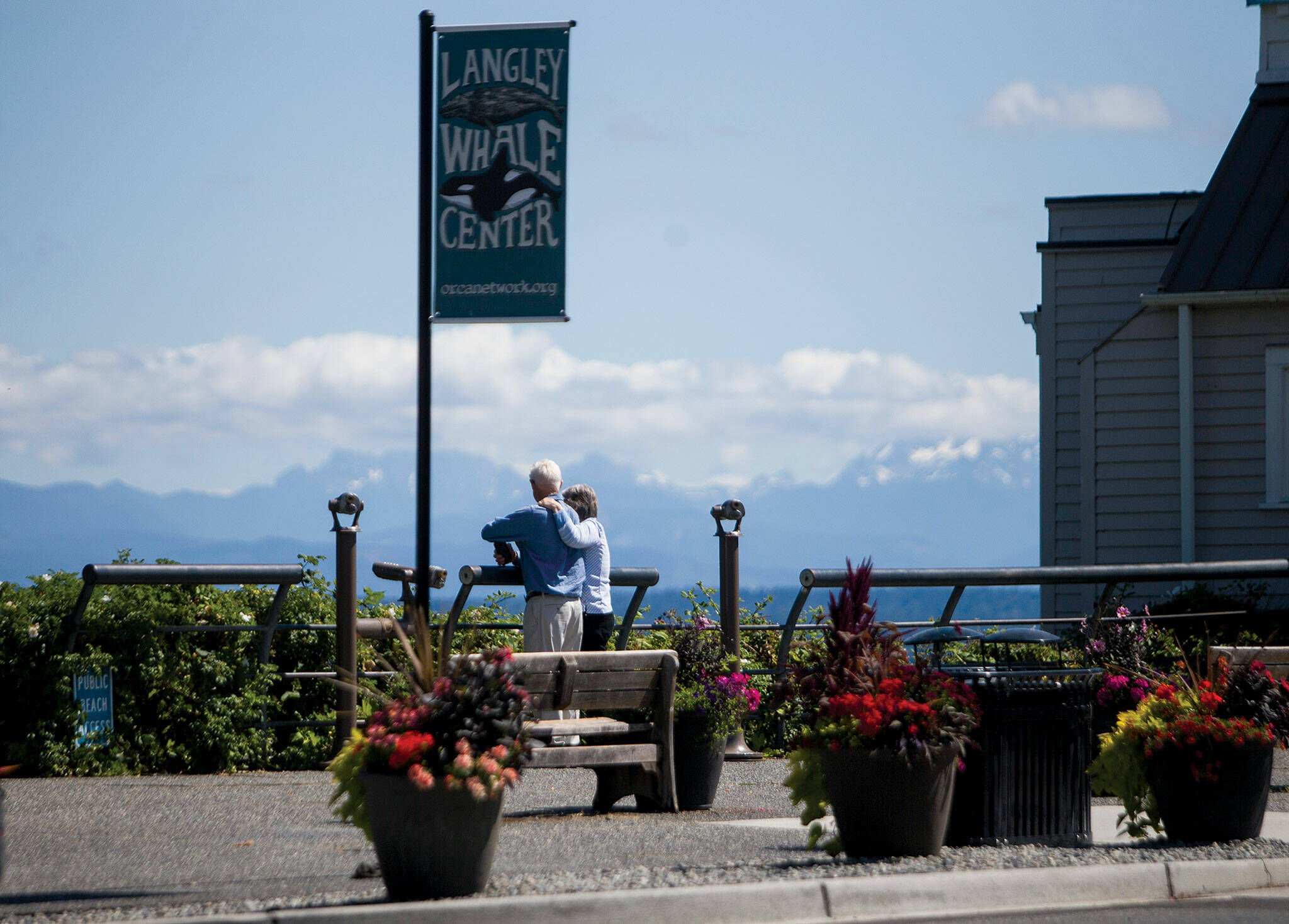 A couple gazes out to Saratoga Passage from Boy and Dog Park in Langley. The park is named for a sculpture by Whidbey Island artist Georgia Gerber. (Olivia Vanni / The Herald)