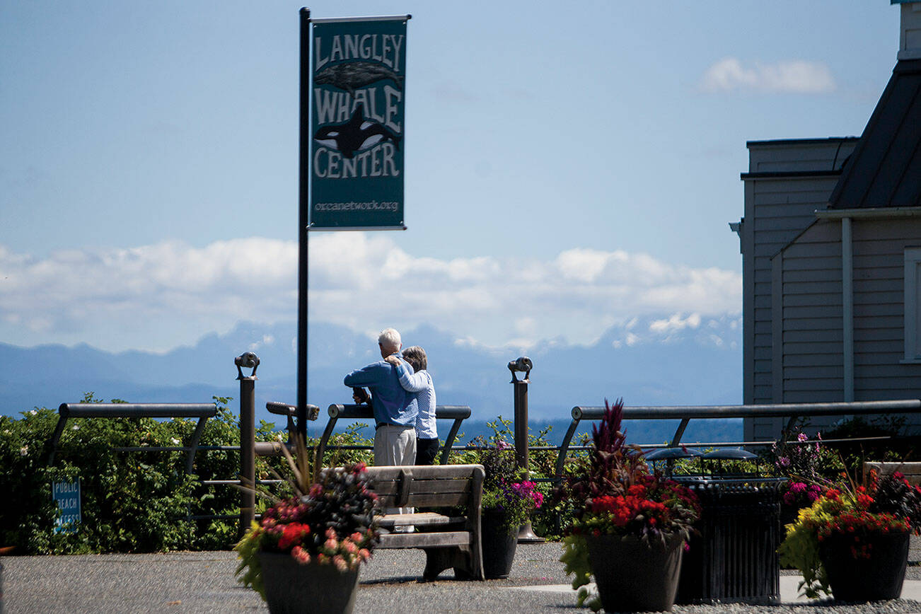 A couple looks out toward the water from Boy and Dog Park on Thursday, July 22, 2021 in Langley, Wash. (Olivia Vanni / The Herald)
