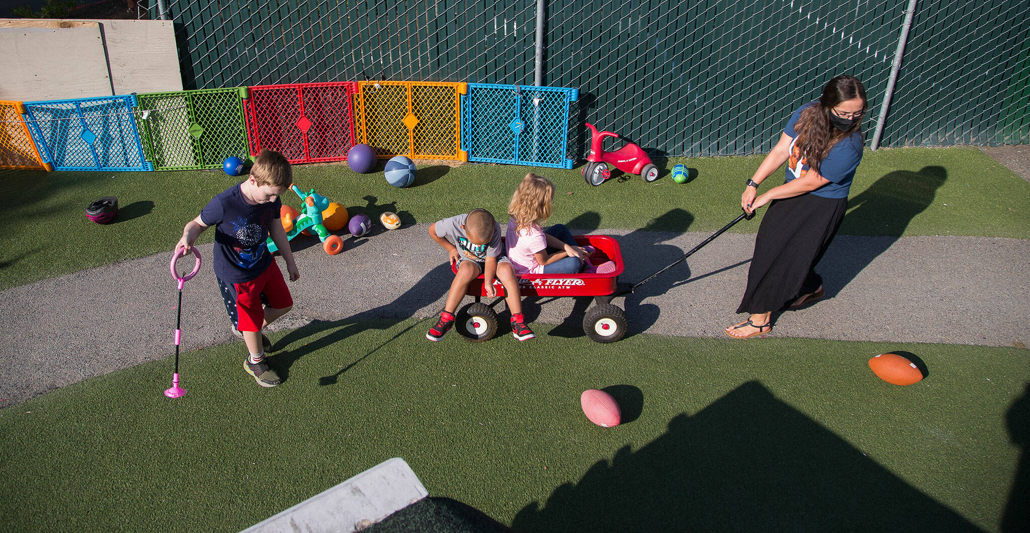 Emilee Swenson pulls children in a wagon at Tomorrow’s Hope child care center Tuesday in Everett. (Andy Bronson / The Herald)