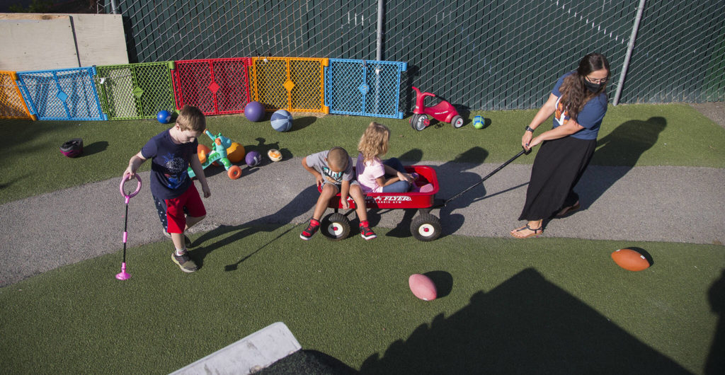 Emilee Swenson pulls children in a wagon at Tomorrow’s Hope child care center Tuesday in Everett. (Andy Bronson / The Herald)
