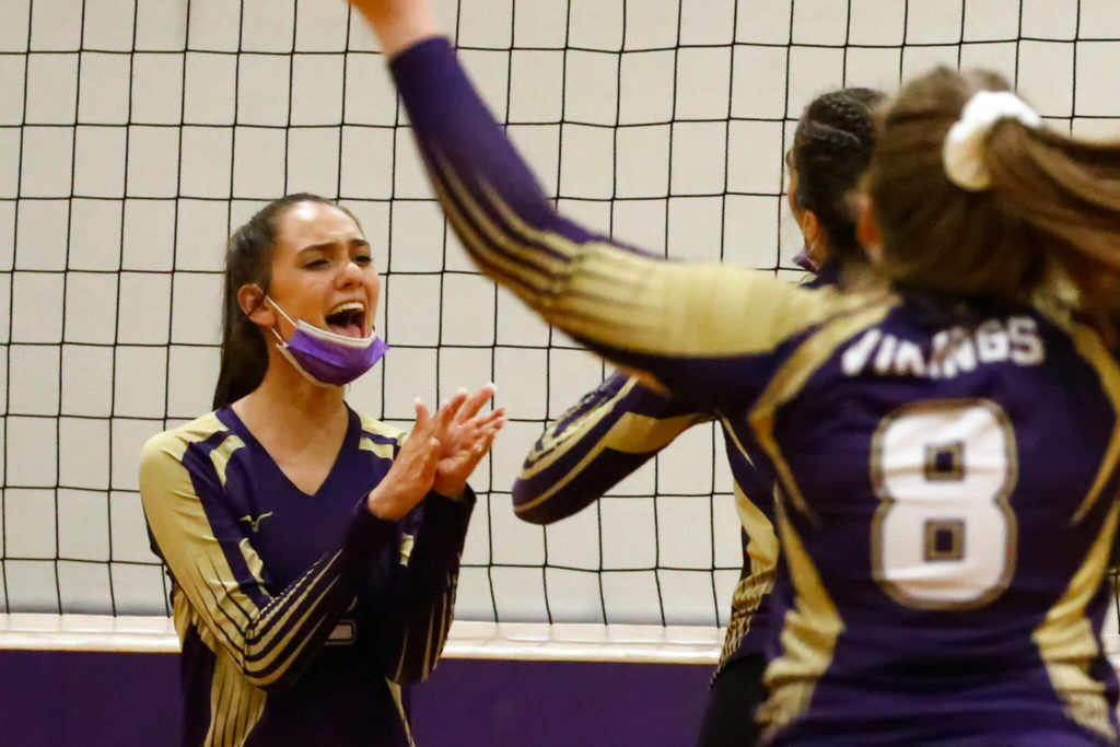 Lake Stevens’ Isabella Christensen, left, celebrates a point with teammates Tuesday night at Edmonds-Woodway High School in Edmonds on September 7, 2021. The Vikings won in straight sets. (Kevin Clark / The Herald)
