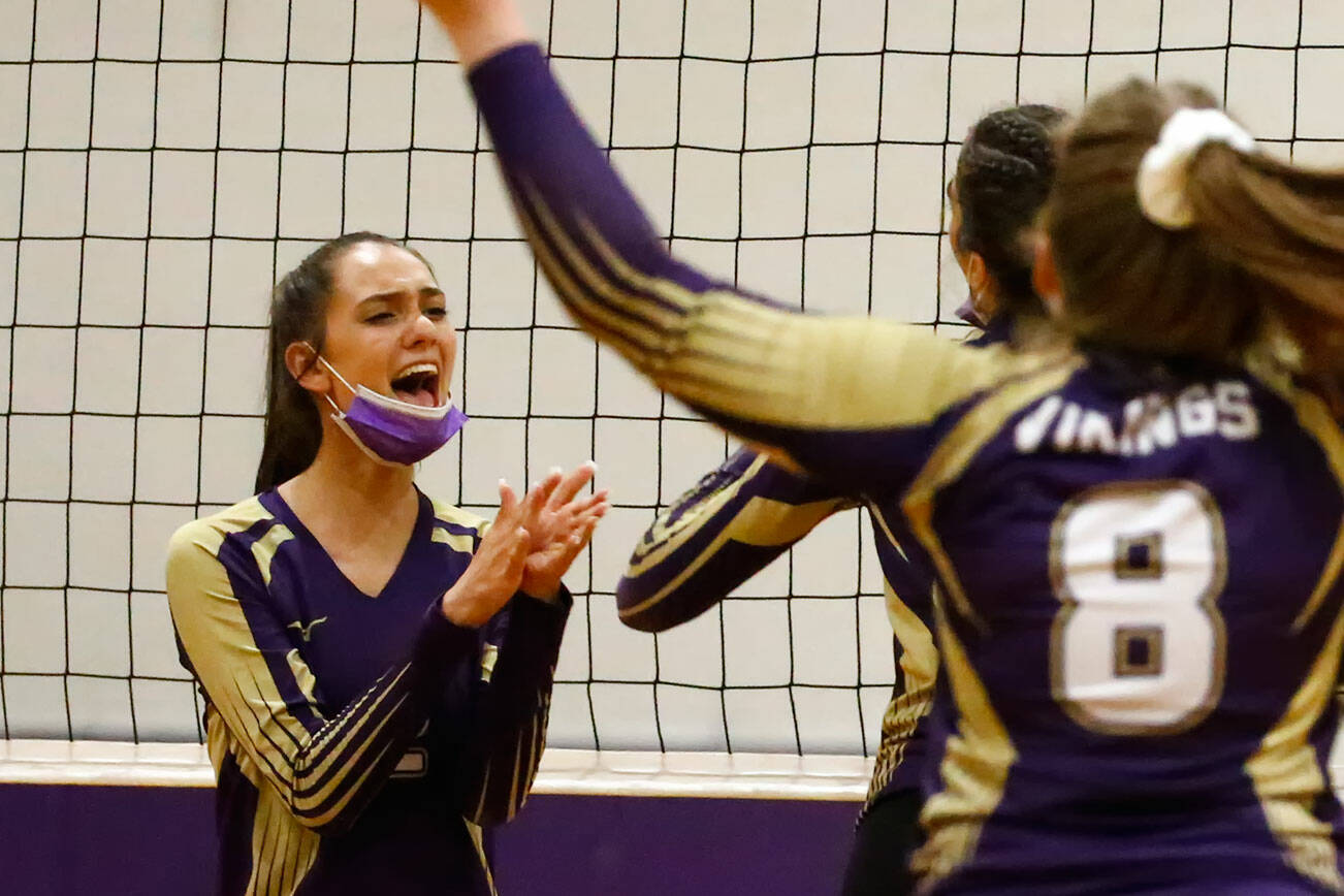 Lake Stevens' Isabella Christensen, left, celebrates a point with teammates Tuesday night at Edmonds-Woodway High School in Edmonds on September 7, 2021. The Vikings won in straight sets. (Kevin Clark / The Herald)